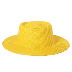 Dettaglio di un cappello di paglia giallo vivace con trama intrecciata e tesa larga.