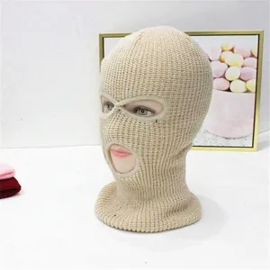 Detailansicht einer beige gestrickten Sturmhaube mit drei Löchern für den Außenbereich