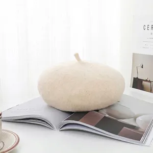 Basco in lana beige morbido su una rivista aperta in un ambiente minimalista