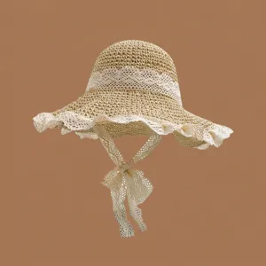 Detaillierte Nahaufnahme von Sommer Strohhut mit eleganter weißer Spitzenverzierung.
