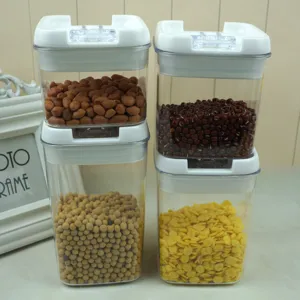Vue détaillée de quatre bocaux de stockage transparents contenant grains et fèves