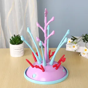 Escurridor de biberones colorido para bebés con ramas de árbol y bandeja de drenaje.
