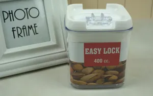 Contenitore trasparente in plastica per alimenti con coperchio bianco per noci e snack.