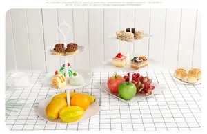 Detailansicht von zwei weißen 3-stöckigen Etagere mit frischem Obst und Gebäck gefüllt.