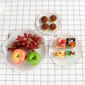 Assiette à fruits à étages blanche de style européen pour snacks sur fond quadrillé