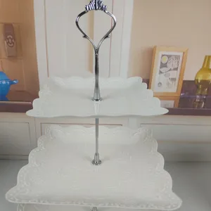 Eleganter weißer 3-stufiger Dessertständer mit dekorativem Wellenrand und silbernem Griff.