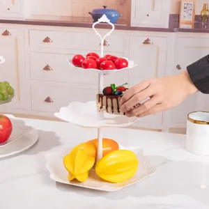 Nahaufnahme eines weißen 3-stöckigen Kunststoff-Dessertständers für Kuchen und Früchte.