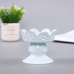 Detail view of a light blue iron dessert stand with delicate lace hollow out design.