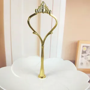Nahaufnahme von elegantem Goldgriff und weißem blütenförmigem Tortenständer