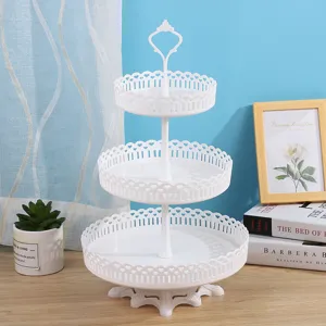 Primer plano de un soporte para pasteles de fruta blanco de tres niveles con corazón.