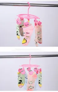 Detailansicht des Plastik-Mehrfachkleiderbügels mit süßen Schweinchen- und Erdbeer-Clips.
