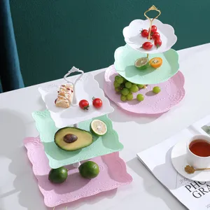 Présentoirs à desserts colorés à trois niveaux avec bords ondulés et garnitures.