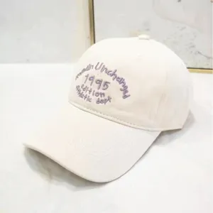 Vista dettagliata del cappellino bianco con ricamo viola 1995 Athletic Dept logo