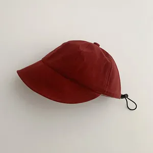 Vista lateral de un sombrero de sol rojo para niños con cordón de ajuste negro