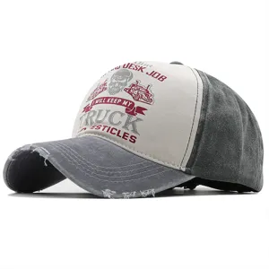 Close-up of vintage washed cotton cap showing distressed brim and skull truck graphic.