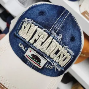 Detaillierte Nahaufnahme des San Francisco Stickereis auf einer gewaschenen Jeans-Mütze