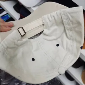Detailansicht der Innenseite und der verstellbaren Metallschnalle einer beige gewaschenen Baumwollkappe.