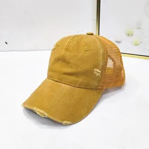 Detaillierte Ansicht einer gelben Distressed Trucker Cap mit Mesh und Rissen.