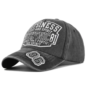 Detail shot of a distressed charcoal grey baseball cap with white 86 embroidery.