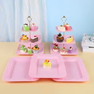 Support à gâteaux rose à 3 niveaux et plateaux de service pour desserts.