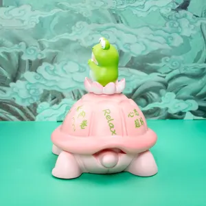 Close-up of a pink turtle storage jar featuring a cute green frog on a lotus flower lid