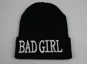 Détail de la broderie 3D blanche 'BAD GIRL' sur un bonnet en acrylique noir tricoté
