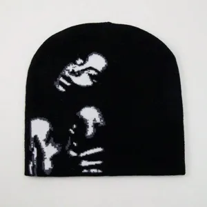 Dettaglio ravvicinato della grafica del viso pixelato su un berretto streetwear nero