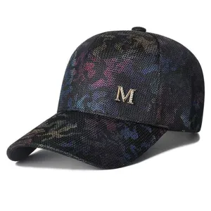 Detailansicht einer glitzernden Mesh-Baseballkappe mit goldenem Metallic-M-Logo-Dekor
