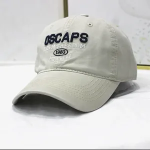 Nahaufnahme einer beigefarbenen Baseballkappe mit Vintage OSCAPS Buchstabenstickerei