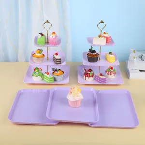 Présentoirs à cupcakes carrés violets à 3 niveaux et plateaux à desserts assortis.