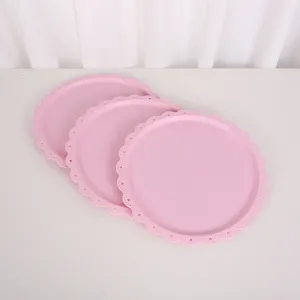 Détail de plateau à dessert en plastique rose, bordure en dentelle pour goûter.