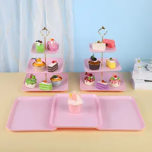 Vue détaillée des présentoirs à gâteaux roses à plusieurs niveaux et plateaux de service.