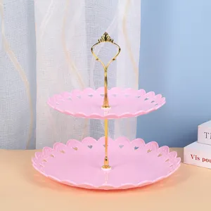 Two-tier pink plastic dessert stand with gold metal handle, perfect for afternoon tea party.