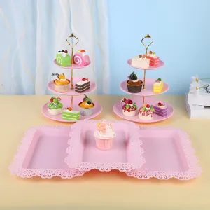 Vue détaillée de plateaux roses à bords dentelés et de présentoirs à gâteaux étagés