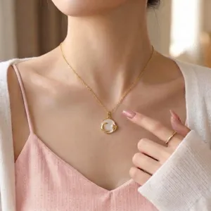 Primo piano di un'elegante collana d'oro con ciondolo a luna e cuore indossata da una donna.