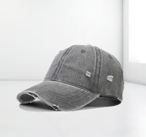 Detailansicht der Distressed-Textur und Risse auf einer grau gewaschenen Baseballkappe.