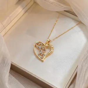 Dettaglio ravvicinato della collana con ciondolo a cuore dorato e zirconi colorati