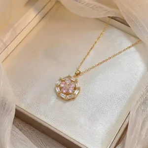 Close-up of gold necklace with zircon flower petal pendant in a luxury jewelry box