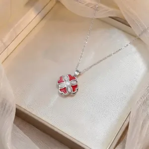 Close-up of elegant red four-leaf clover necklace with sparkling cubic zirconia center