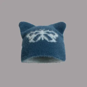 Details einer flauschigen Katzenohren-Strickmütze mit Schmetterlingsmotiv