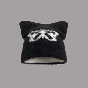 Detailansicht der schwarzen Nerzimitat-Mütze mit Katzenohren und weißem Schleifenmuster