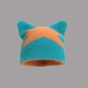 Detailaufnahme der blau-orangen Strickmütze mit Katzenohren und Sternmuster