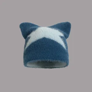 Detailansicht einer blauen, flauschigen Katzenohren-Mütze mit weißem Sternmuster aus Kunstpelz