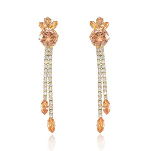 Vue détaillée de boucles d'oreilles en zircon orange avec pompons en strass brillants