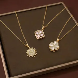 Détail de trois colliers en or élégants avec des pendentifs fleur et flocon en zircon