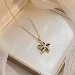 Close-up detail of a gold starfish pendant necklace with sparkling cubic zirconia