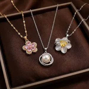 Vue détaillée de colliers élégants avec pendentifs fleurs et perles dans un écrin.