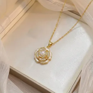 Détail d'un élégant pendentif en forme de camélia doré avec zircons étincelants et perle