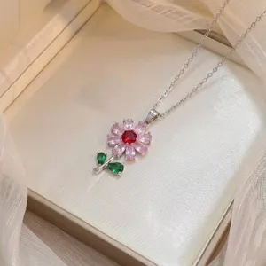 Vue détaillée d'un élégant collier avec pendentif fleur en zircons roses et rouges