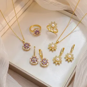 Elegante conjunto de joyas con circón púrpura y flores de perlas en caja de regalo.
